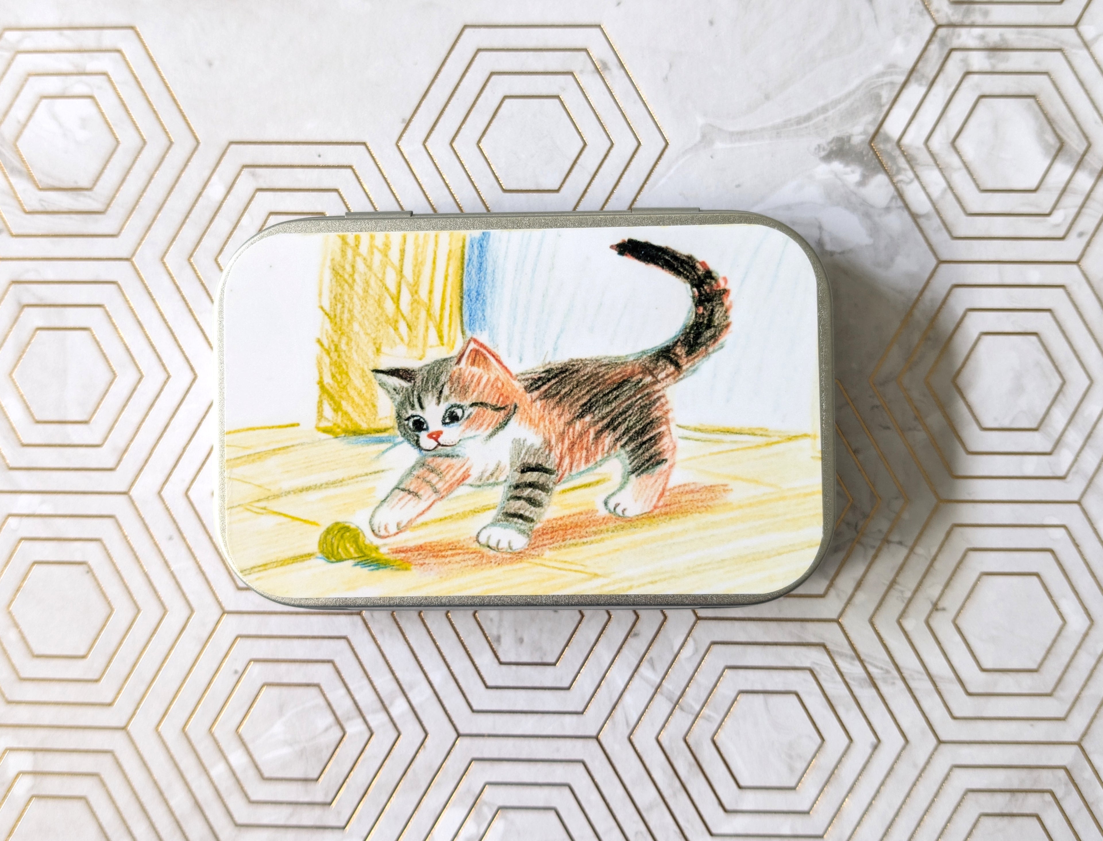 Crayon Cat and their Ball of Yarn. Catnip Tin