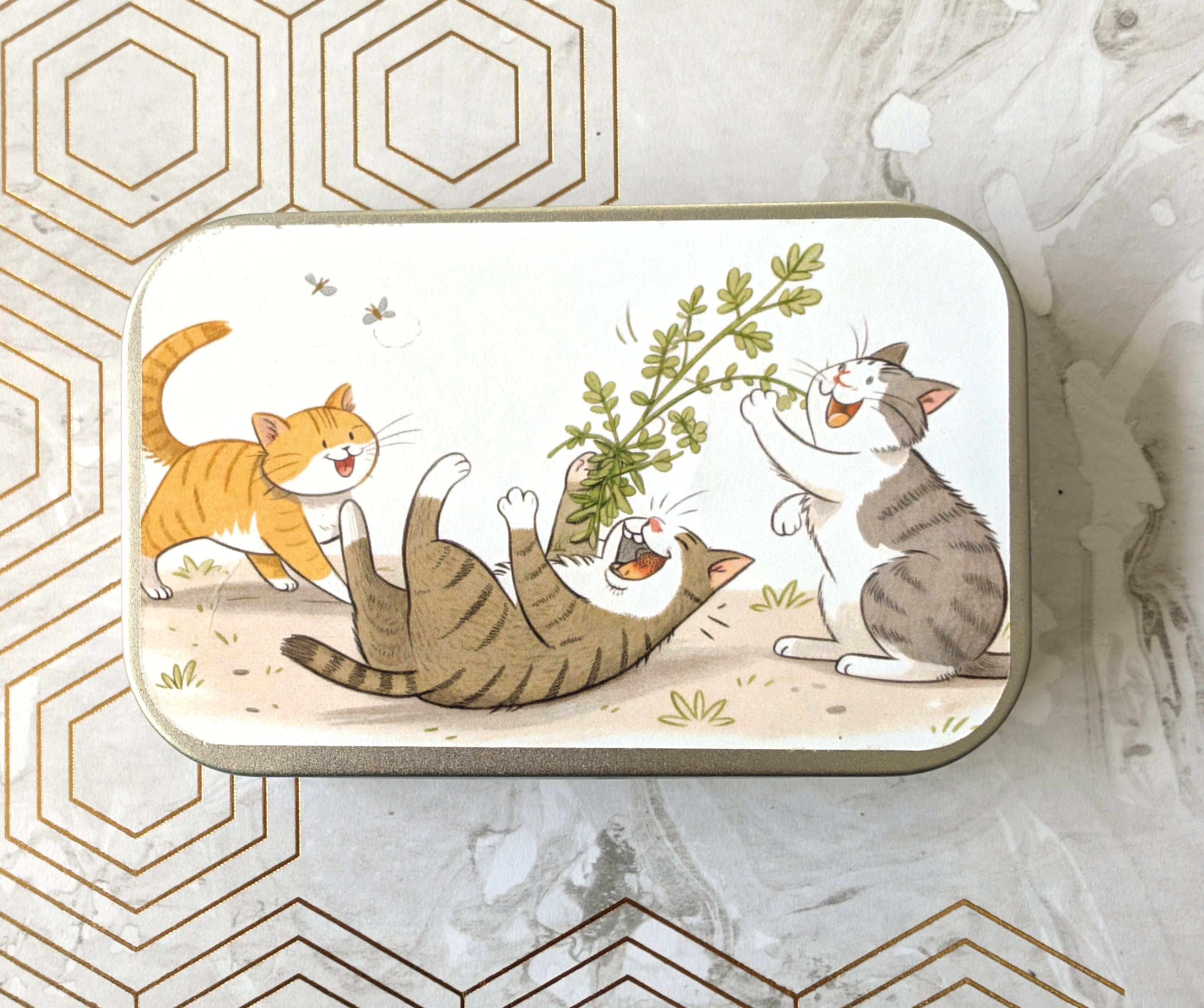 Three cats being Playful Catnip Tin